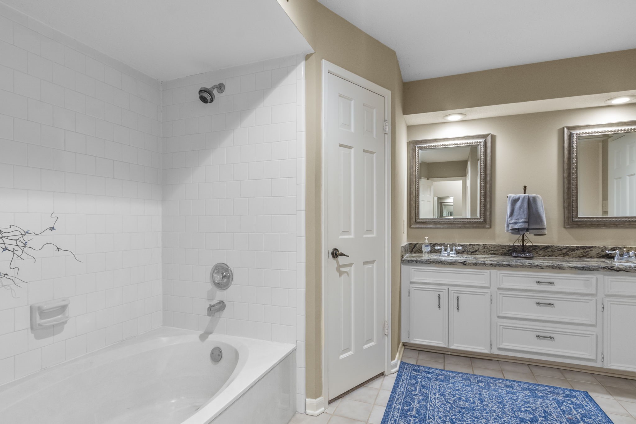 17710 Treeloch Lane Spring, TX 77379 - Photo 26 of 45 a bathroom with a granite countertop sink a mirror a bathtub and shower
