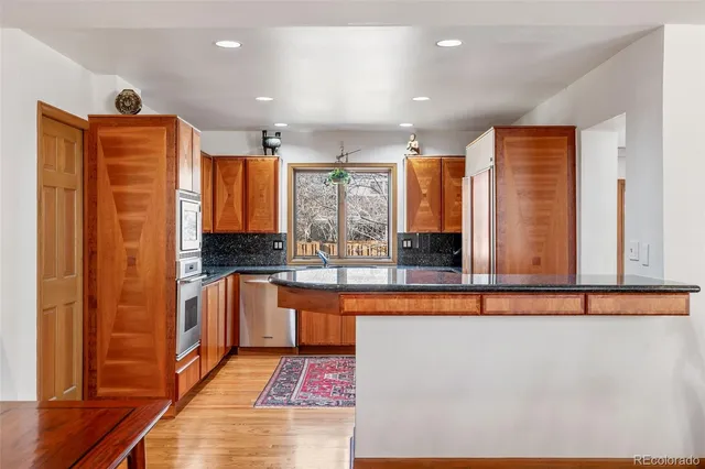 a kitchen with stainless steel appliances granite countertop a stove a sink and a microwave