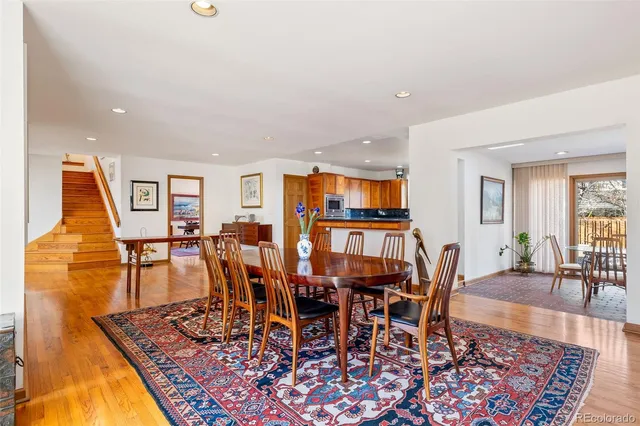 a dining room with furniture a rug and a view of kitchen