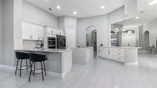 a kitchen with stainless steel appliances kitchen island granite countertop a stove a sink and a refrigerator