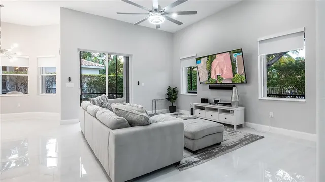 a living room with furniture a flat screen tv and a large window