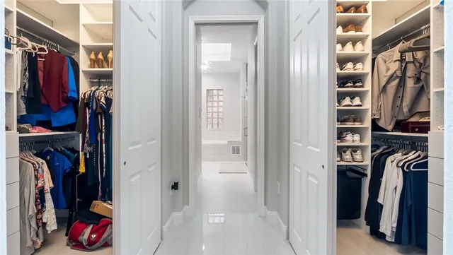 a view of walk in closet with clothes and shoes