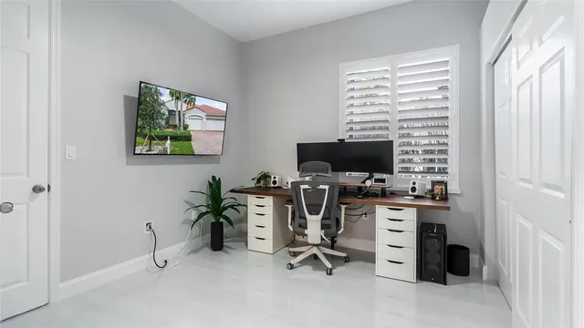 a view of a workspace with furniture and a window