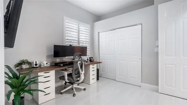 a view of a workspace with furniture and a window