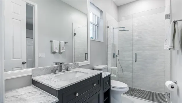 a bathroom with a sink toilet double vanity and shower