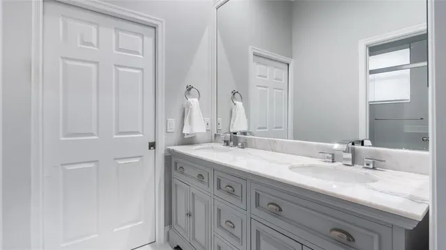 a bathroom with double vanity sink and a mirror