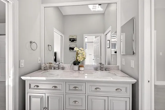 a bathroom with a granite countertop sink and a mirror
