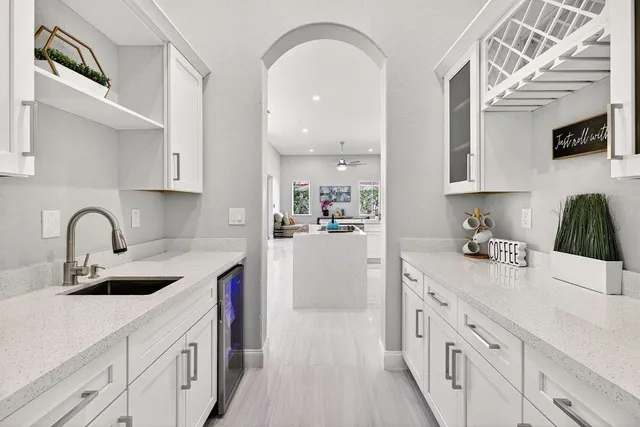 a kitchen with white cabinets a sink and appliances