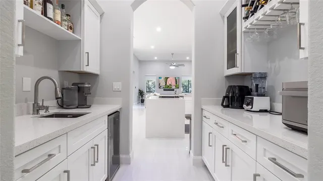 a kitchen with white cabinets and sink