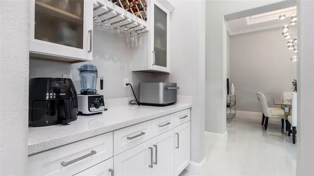 a kitchen with white cabinets and sink