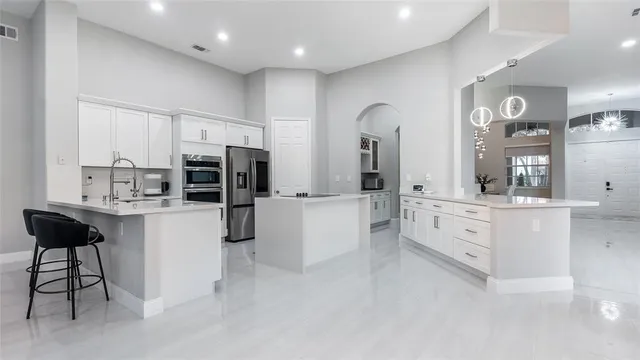 a kitchen with stainless steel appliances kitchen island granite countertop a refrigerator and cabinets