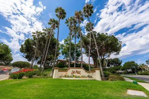 a view of a white house with a big yard and large trees