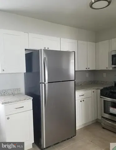 a kitchen with a refrigerator sink and cabinets
