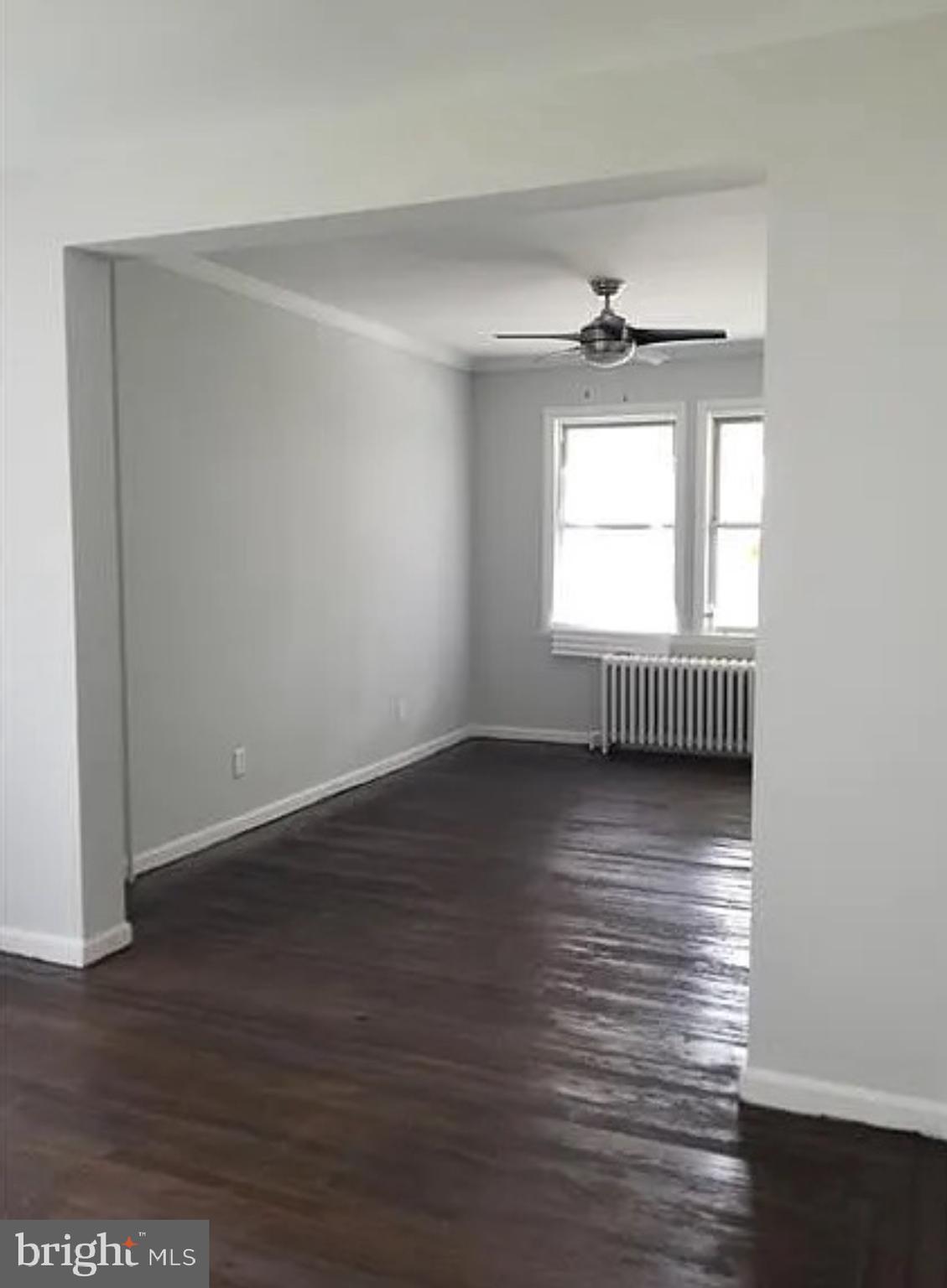 4614 Kavon Avenue Baltimore, MD 21206 - Photo 3 of 3 an empty room with wooden floor and windows