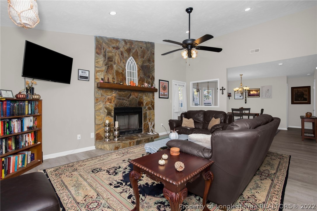 930 Rim Road Fayetteville, NC 28314 - Photo 6 of 30 a living room with furniture a flat screen tv and a fireplace