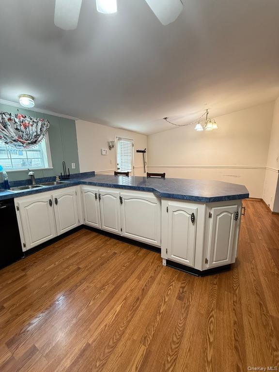 551 5th Avenue Middletown, NY 10941 - Photo 12 of 25 Kitchen with dark countertops, wood finished floors, a chandelier, dishwasher, and white cabinetry