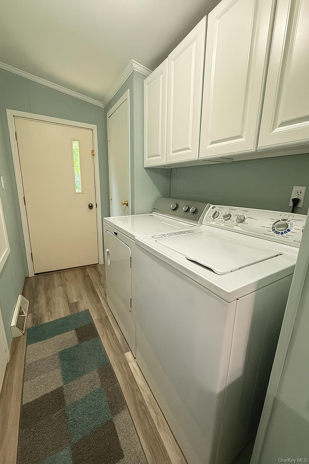 551 5th Avenue Middletown, NY 10941 - Photo 14 of 25 Laundry room with cabinet space, washer and clothes dryer, light wood-style floors, and crown molding