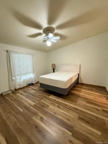 a bedroom with a bed and a ceiling fan
