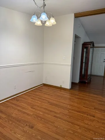 a view of a room with wooden floor and chandelier