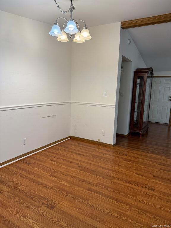 551 5th Avenue Middletown, NY 10941 - Photo 4 of 25 Empty room featuring a chandelier, wood finished floors, and vaulted ceiling