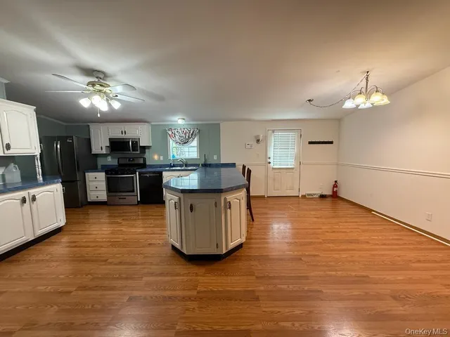 a kitchen with stainless steel appliances granite countertop a stove top oven a sink a counter space and cabinets