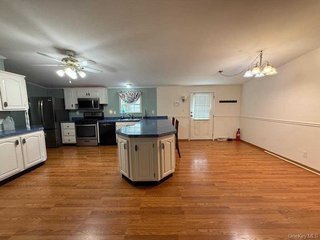 551 5th Avenue Middletown, NY 10941 - Photo 8 of 25 Kitchen with stainless steel appliances, a peninsula, dark countertops, a chandelier, and white cabinetry