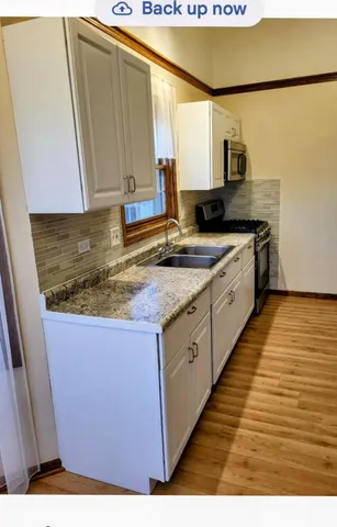 a kitchen with stainless steel appliances granite countertop a sink stove and cabinets