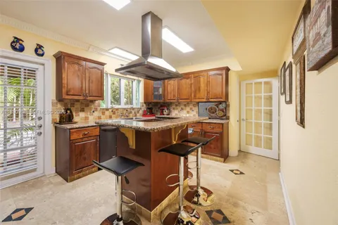 a kitchen with a refrigerator a sink dishwasher a stove and a oven with wooden cabinets
