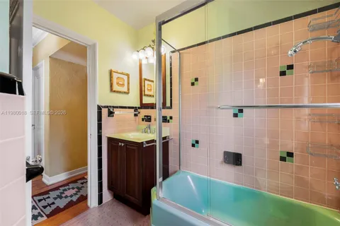 a bathroom with a tub a sink and a shower