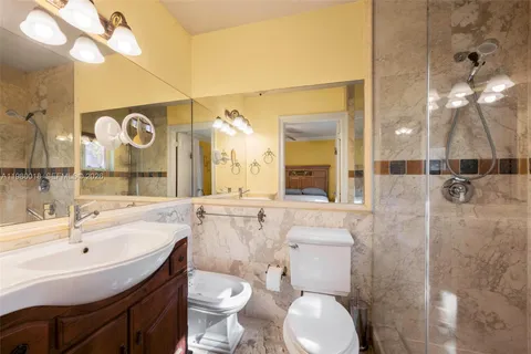 a bathroom with a sink a toilet a mirror and shower
