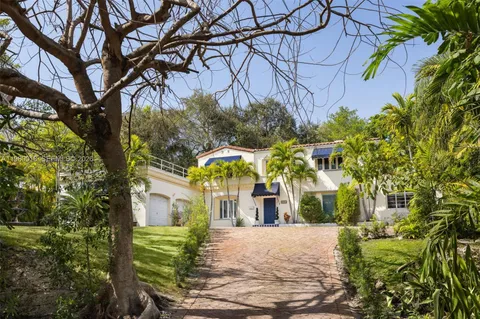 a front view of a house with a yard and trees