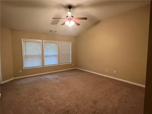 en empty room with windows and ceiling fan