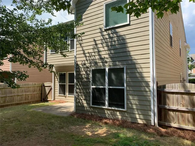 a view of a house with a yard and large tree