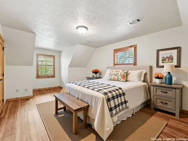 a bedroom with a bed and wooden floor