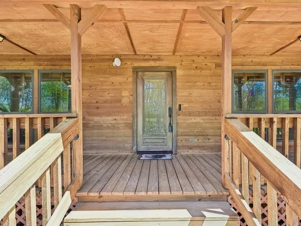 a view of a balcony with wooden floor and fence
