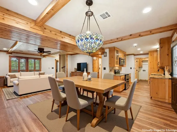 a dining room with furniture a chandelier and wooden floor