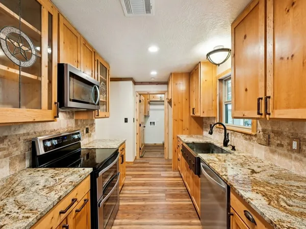 a large kitchen with stainless steel appliances granite countertop a stove and a sink