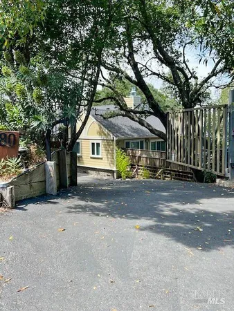 a view of a house with a yard and large trees