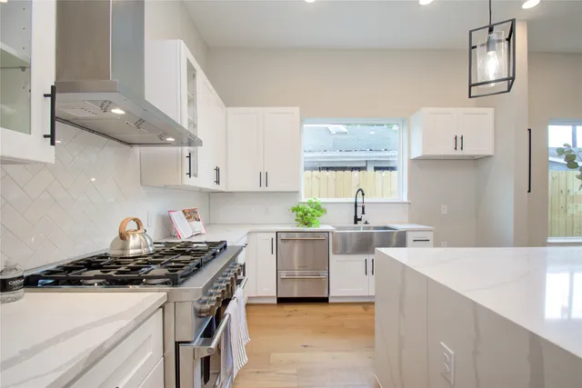 a view of kitchen with stainless steel appliances wooden floor dining table and chairs