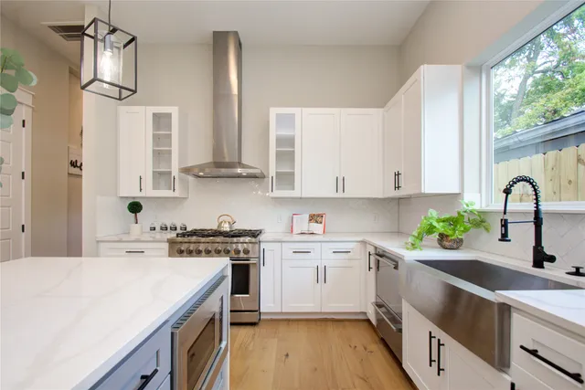 a kitchen with stainless steel appliances kitchen island a stove a sink and a refrigerator