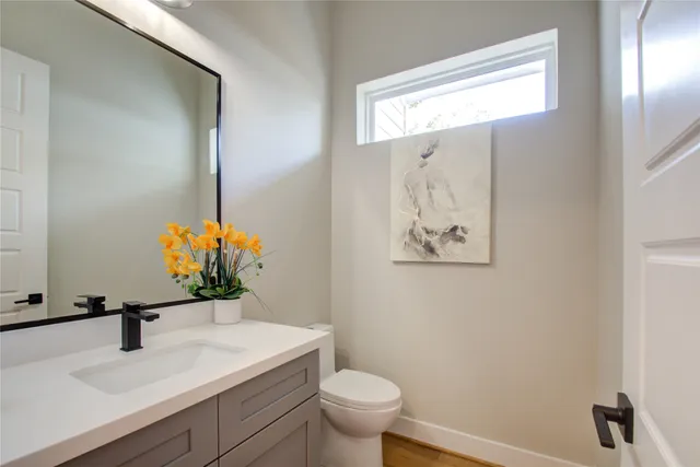 an empty room with wooden floor and bathroom