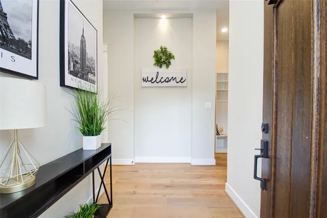 a view of a hallway with wooden floor and a potted plant