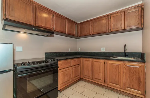 a kitchen with granite countertop cabinets stainless steel appliances and a sink