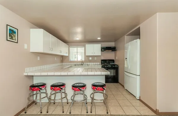 a kitchen with granite countertop refrigerator and cabinets