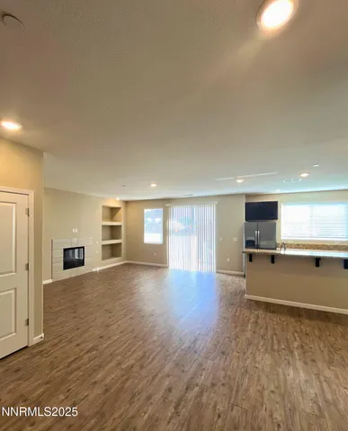 a view of an empty room with a fireplace and a window