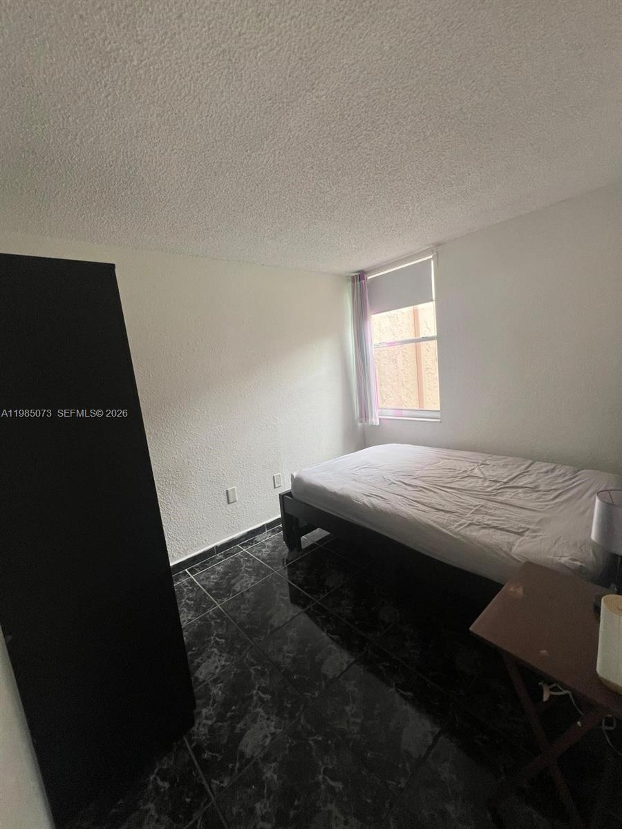 1900 West 68th Street, Unit D207 Hialeah, FL 33014 - Photo 29 of 33 a bedroom with a bed and a window