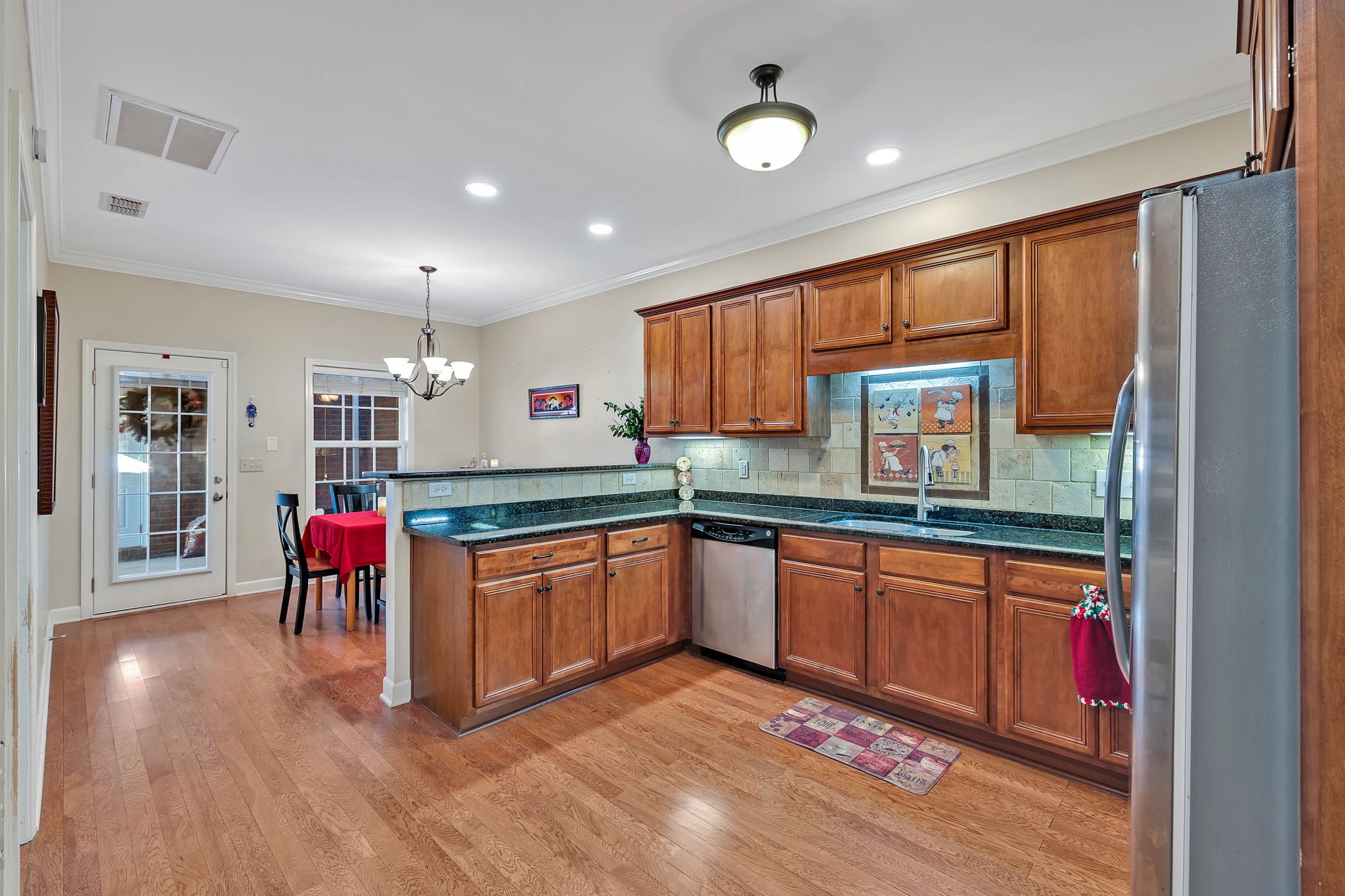 2138 Cason Lane Murfreesboro, TN 37128 - Photo 15 of 55 a kitchen with stainless steel appliances granite countertop a refrigerator a sink dishwasher a dining table and chairs with wooden floor