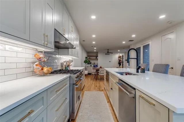 a kitchen with a sink stainless steel appliances lots of counter top space and cabinets