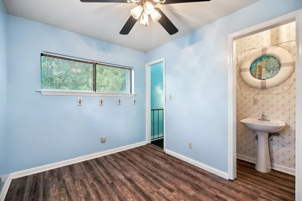 a view of an empty room with a window and wooden floor