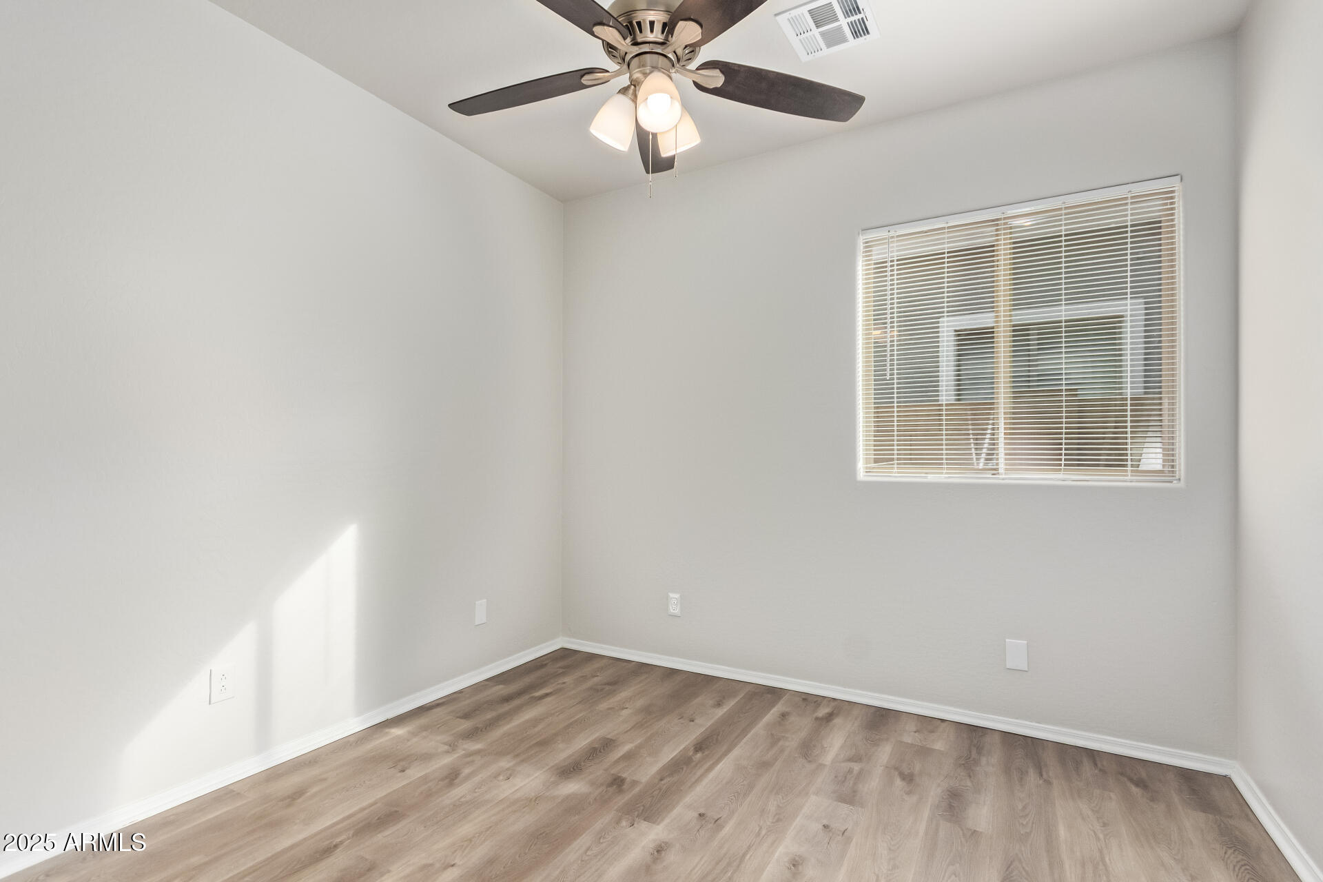 21382 East Via Del Rancho Queen Creek, AZ 85142 - Photo 17 of 29 an empty room with wooden floor chandelier fan and windows